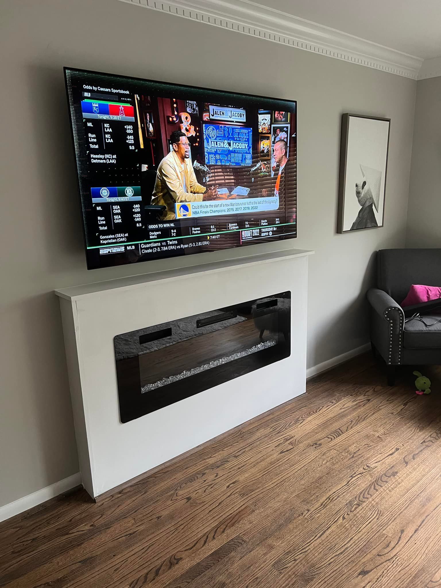 A living room with a fireplace and a flat screen tv mounted to the wall.