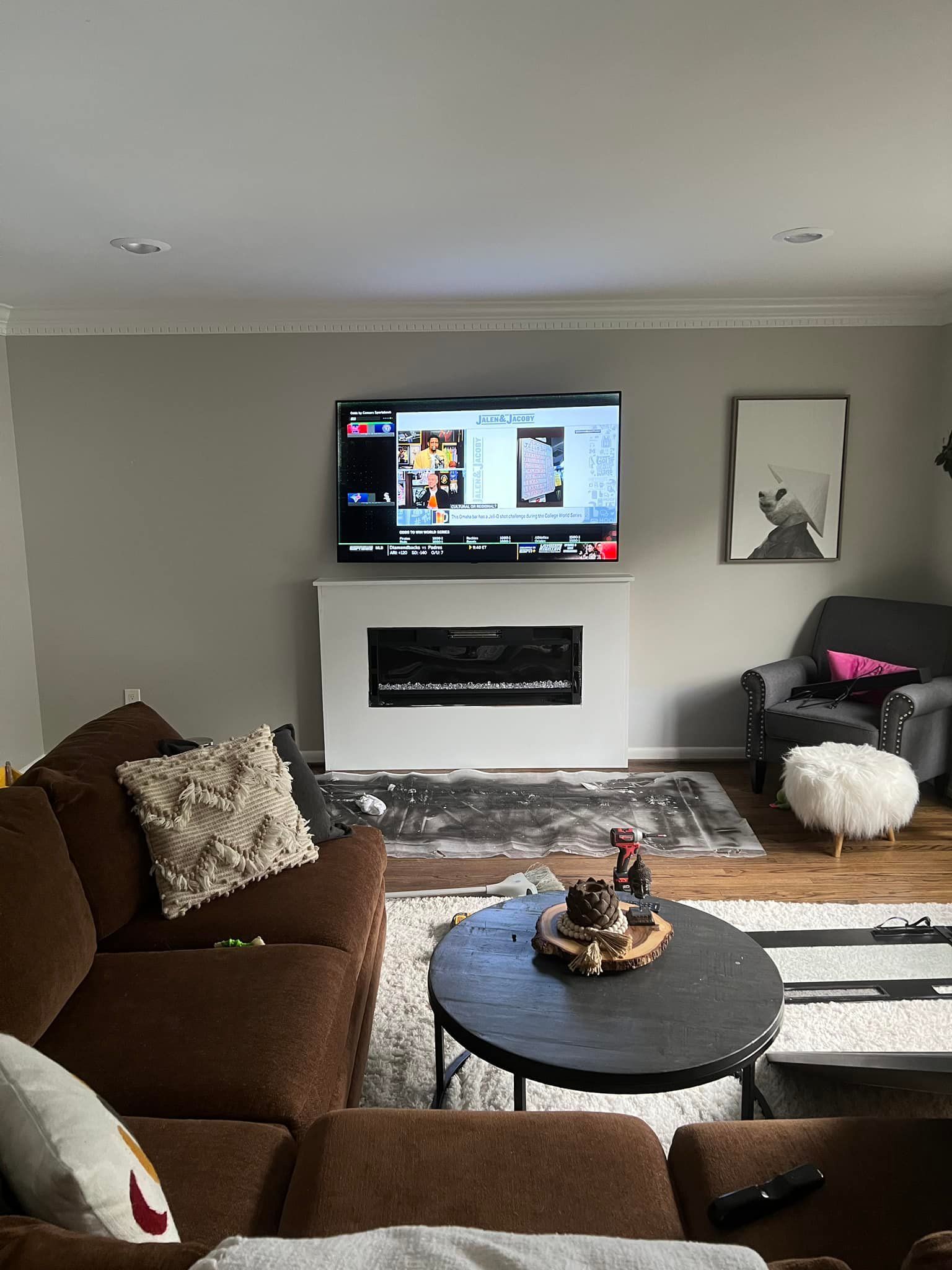 A living room with a fireplace , couch , table and television.