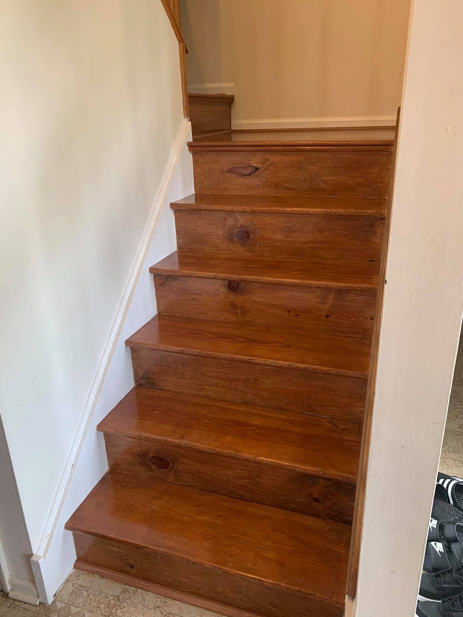 A wooden staircase with a white railing in a house.