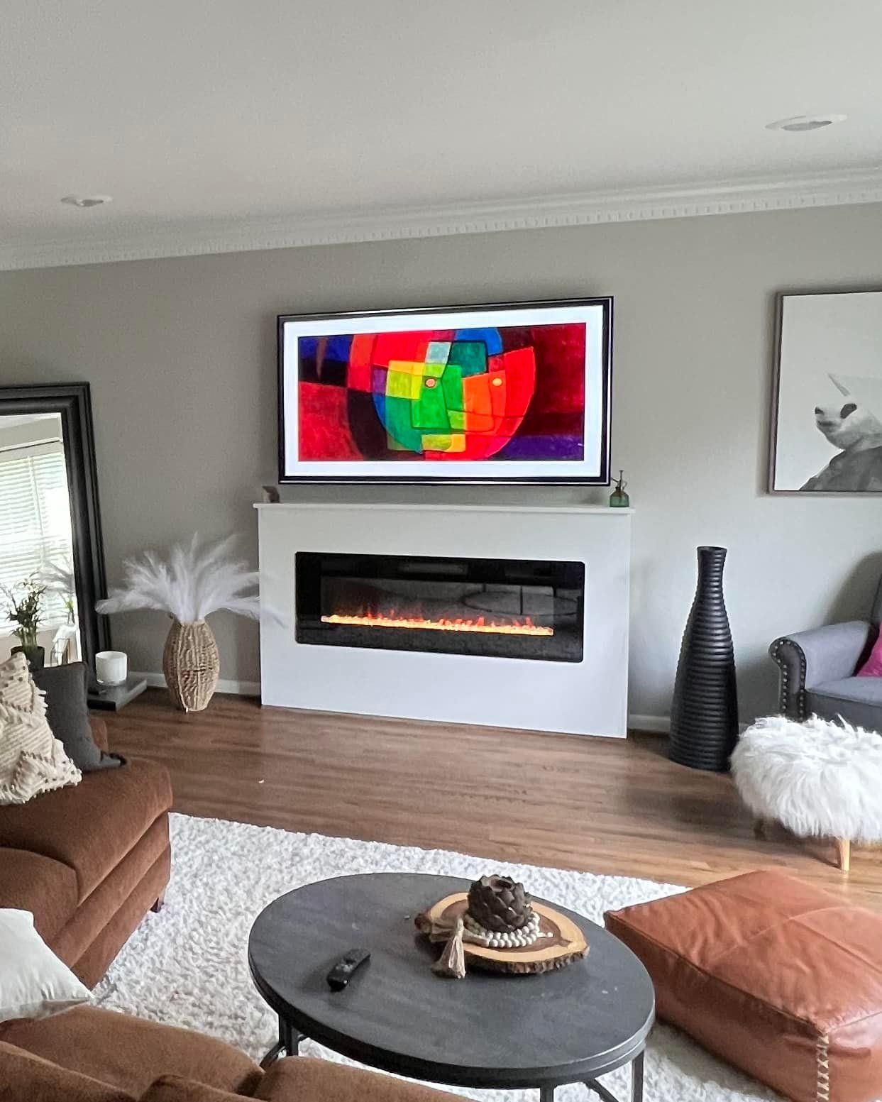 A living room with a fireplace and a flat screen tv on the wall.