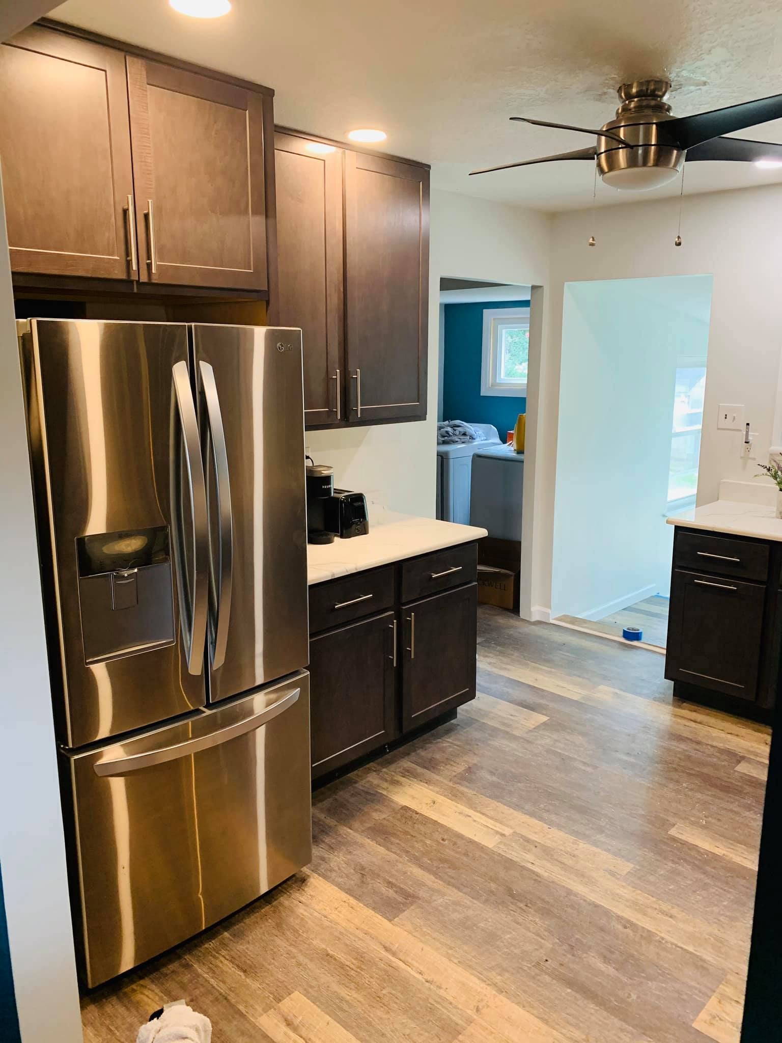 A kitchen with stainless steel appliances and a ceiling fan.