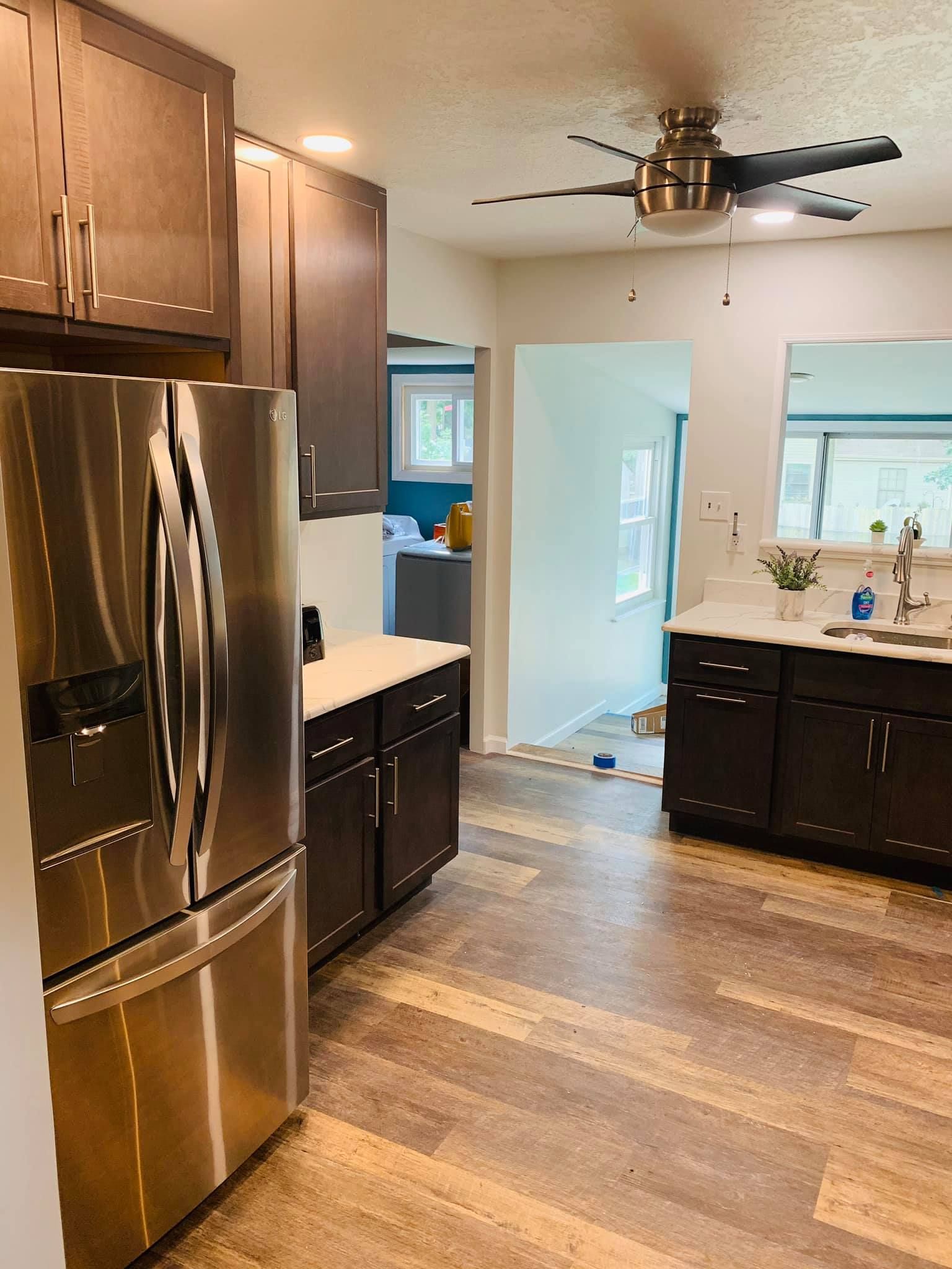 A kitchen with stainless steel appliances and a ceiling fan.
