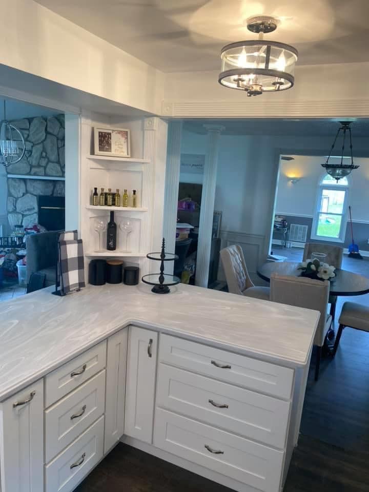 A kitchen with white cabinets and a large island in the middle of the room.