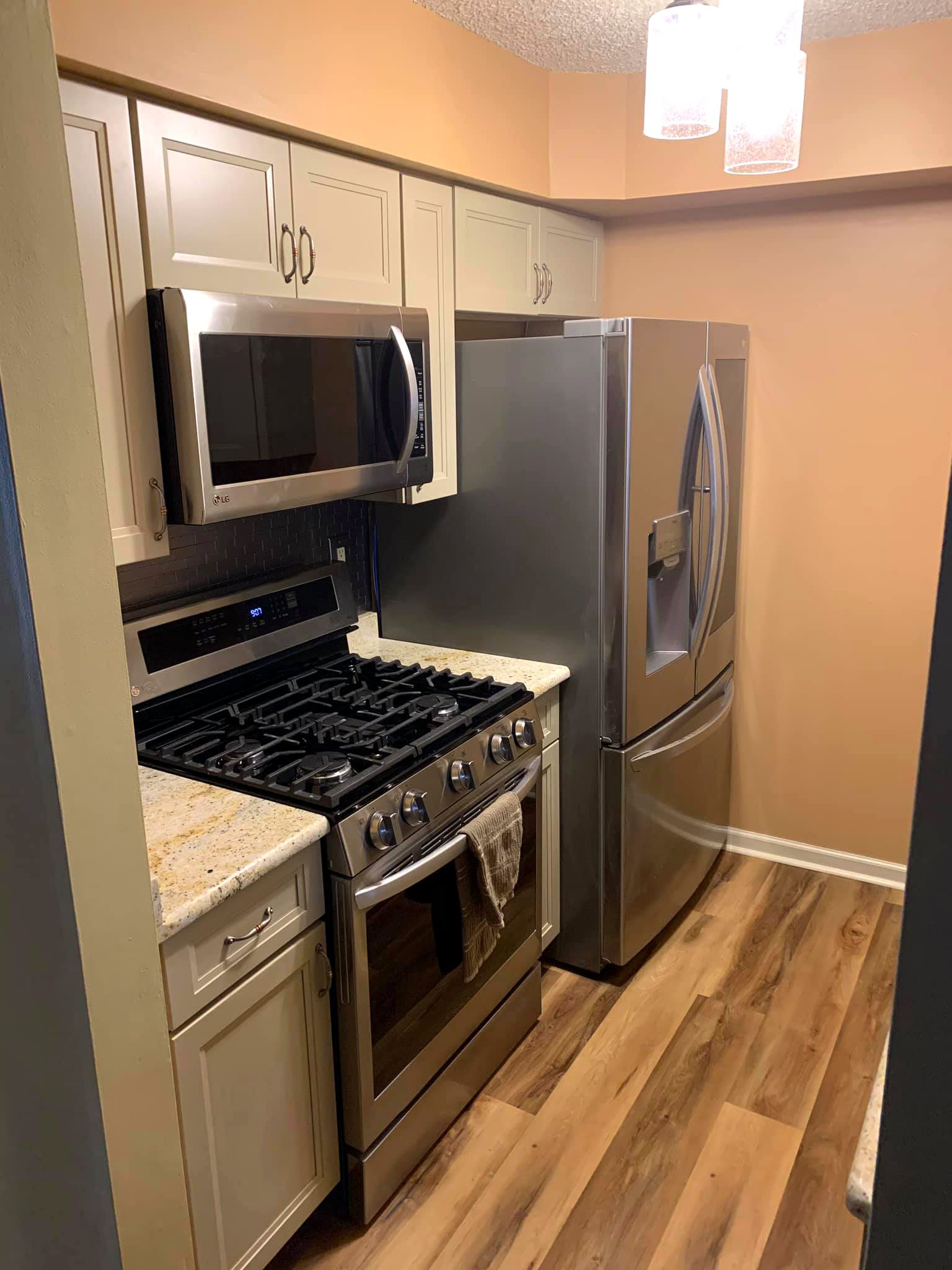A kitchen with a stove , refrigerator , microwave and dishwasher.