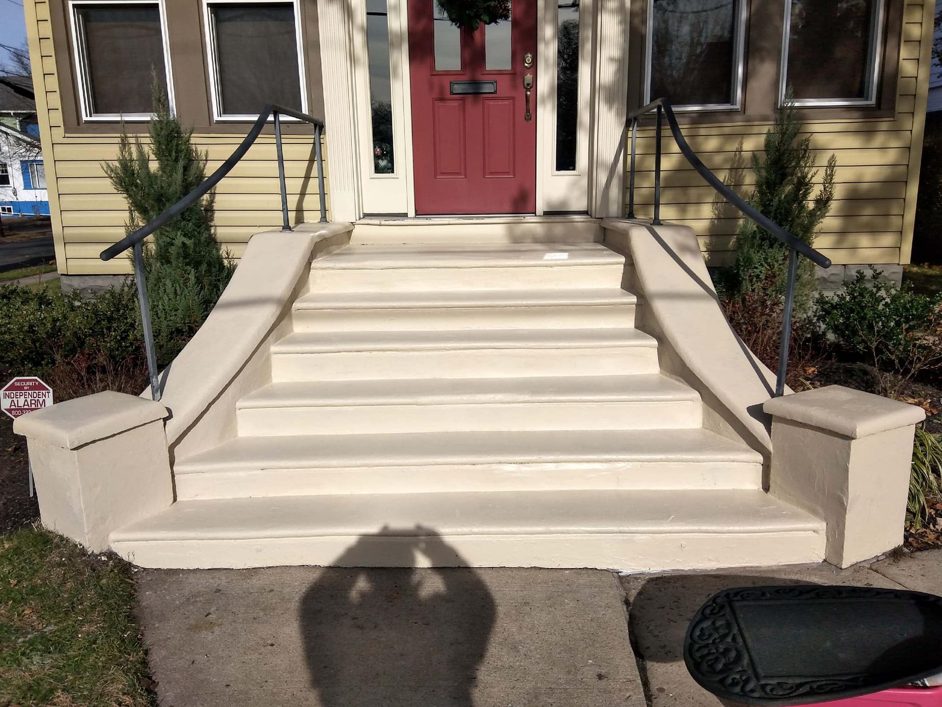 A set of stairs leading up to a house with a red door