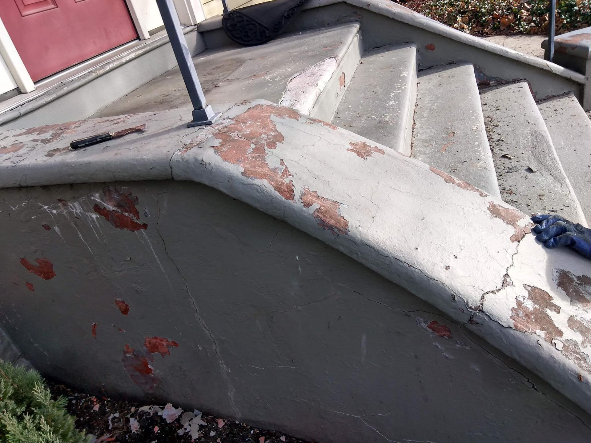 A set of stairs with a red door in the background