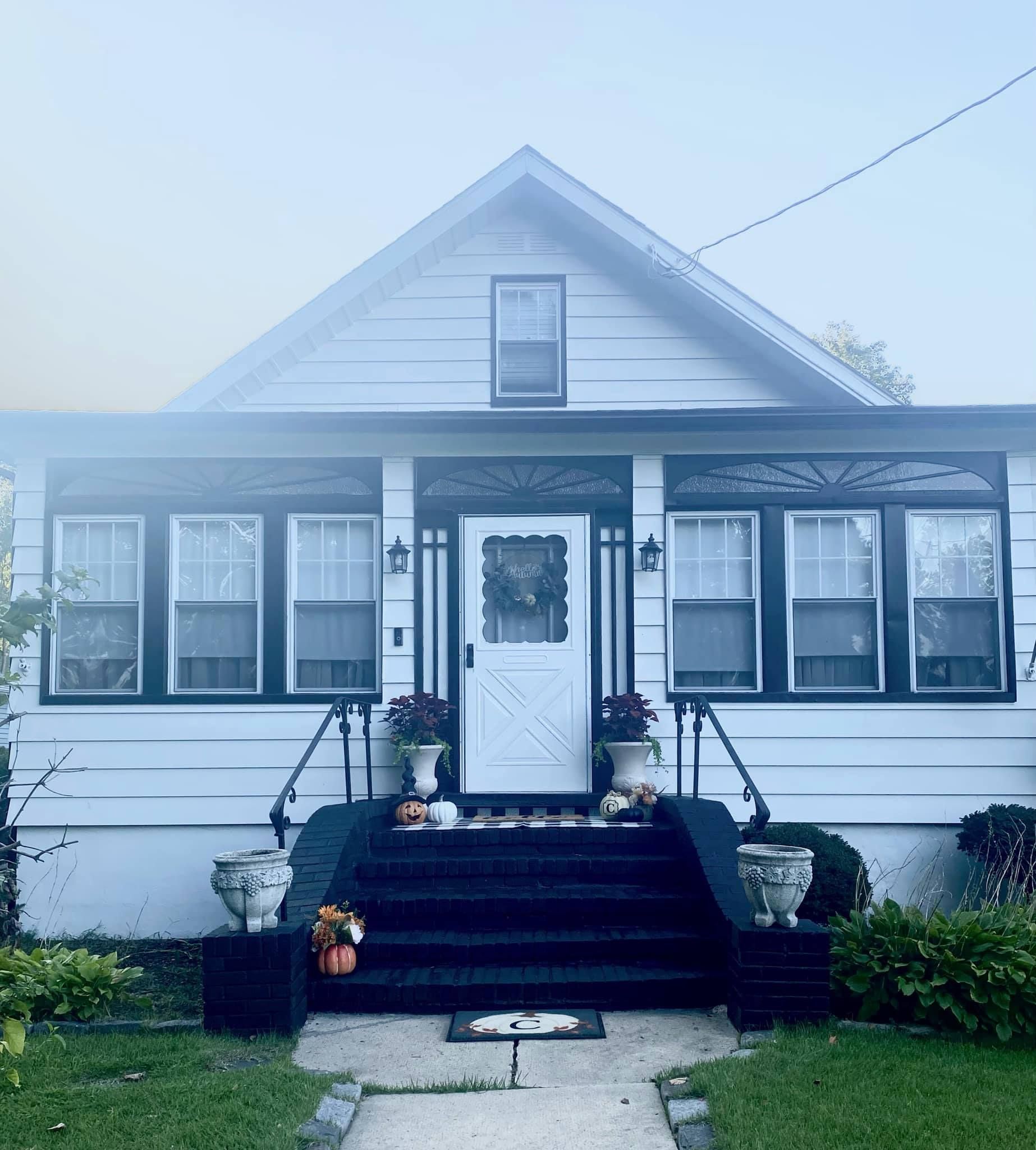 A white house with black steps and a white door