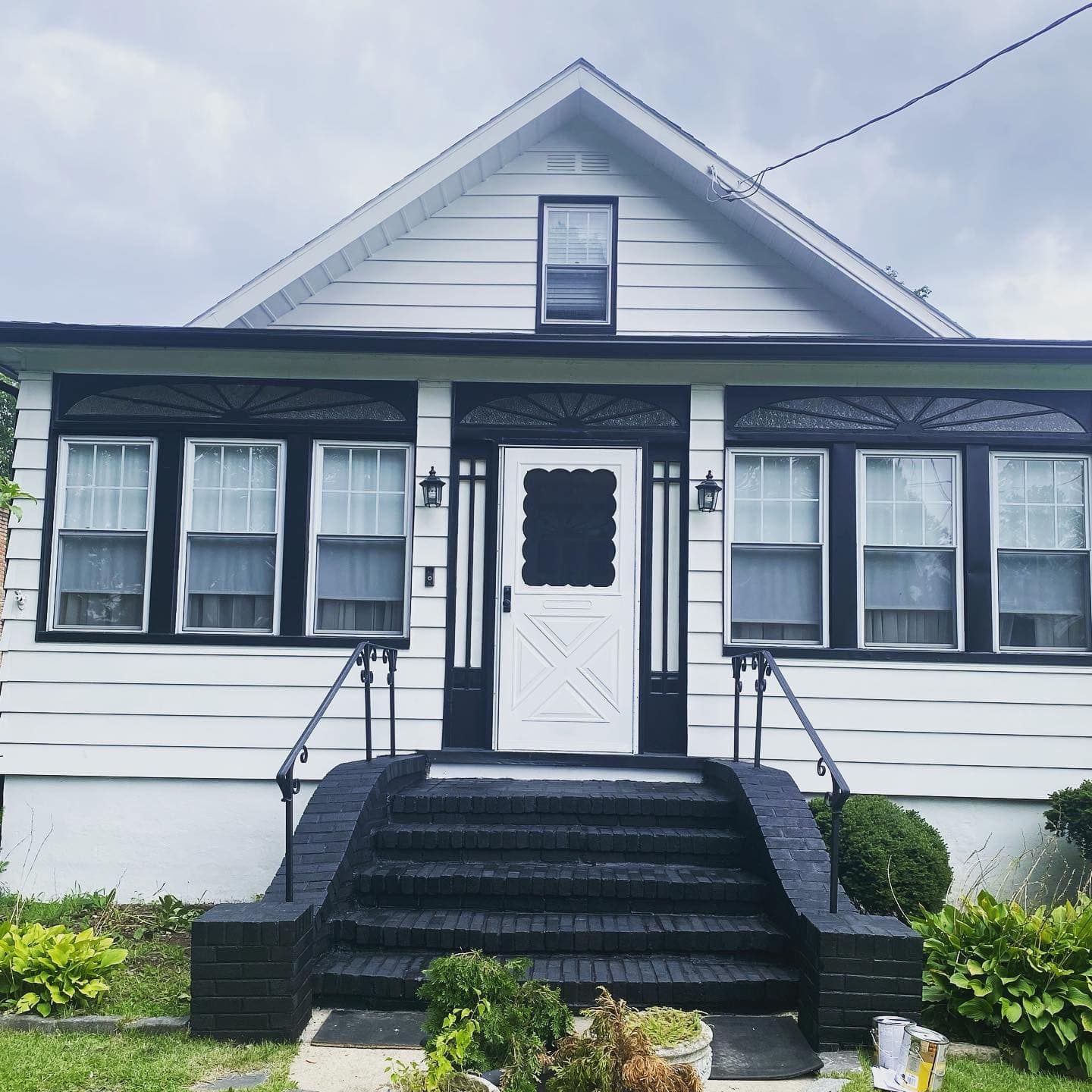 A white house with black trim and stairs