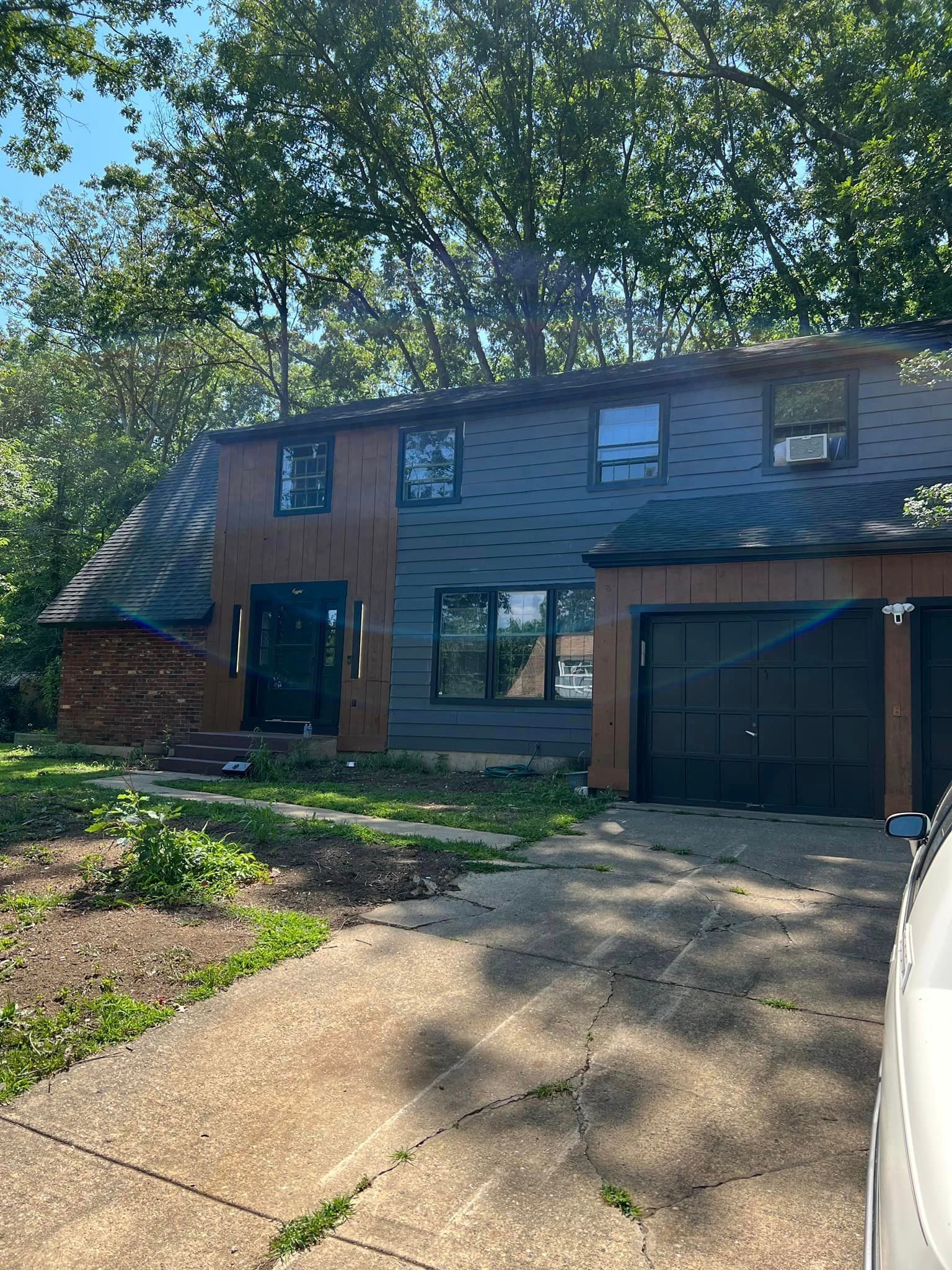 A house with a garage and a car parked in front of it.