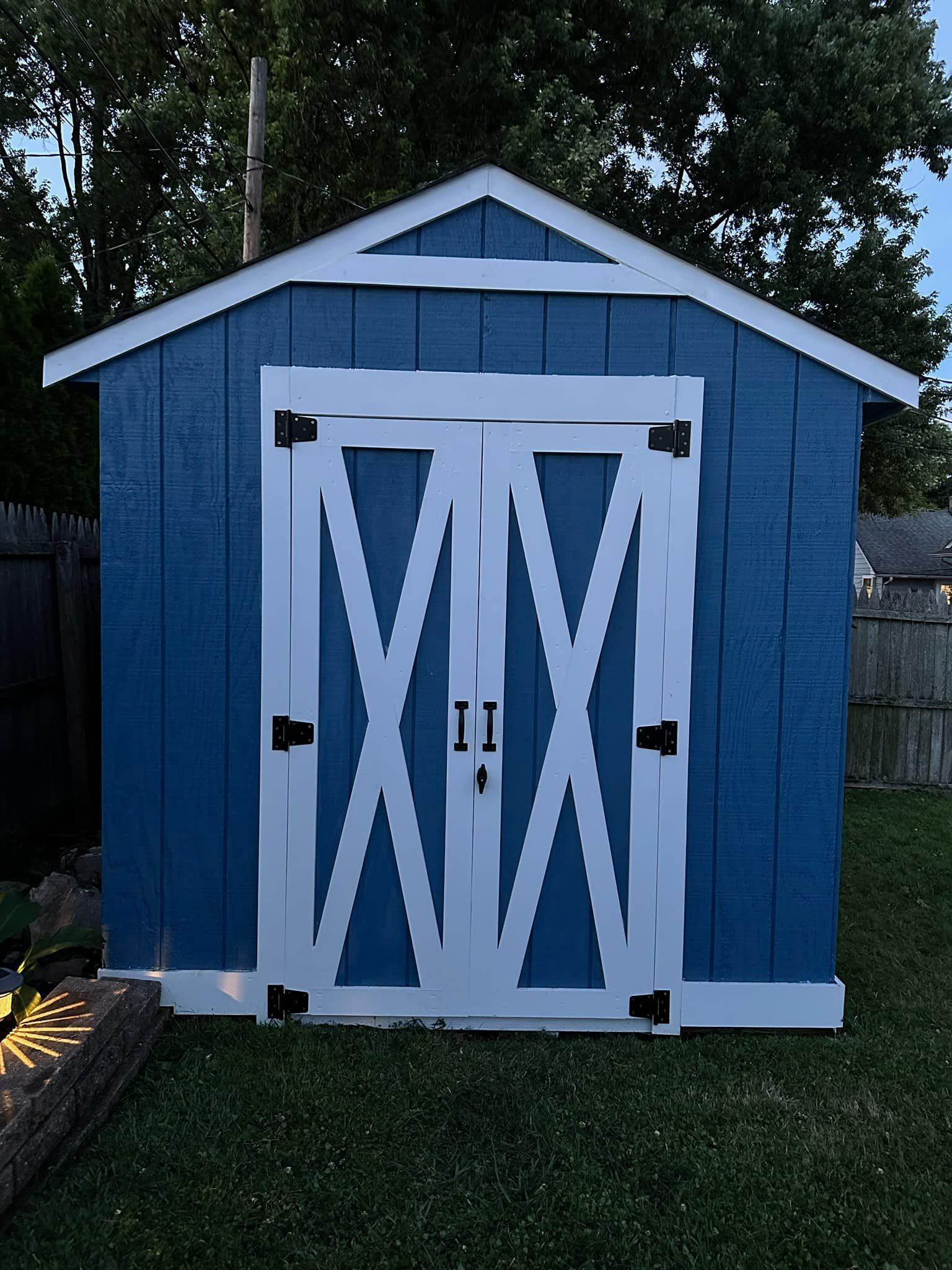 A blue and white shed with a x on the door