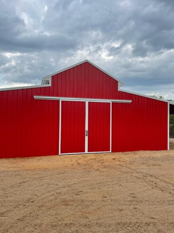 Front view of custom metal barn with bold color and clean design.
