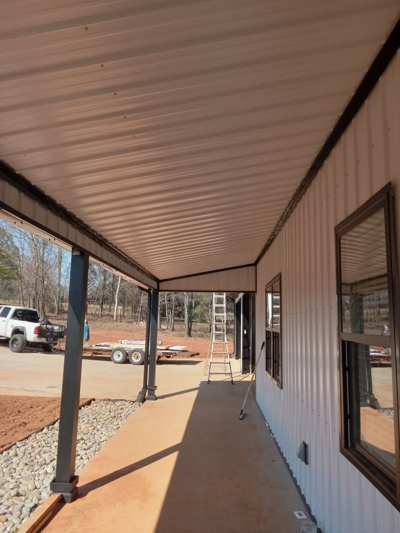 A long walkway leading to a house with a covered porch.
