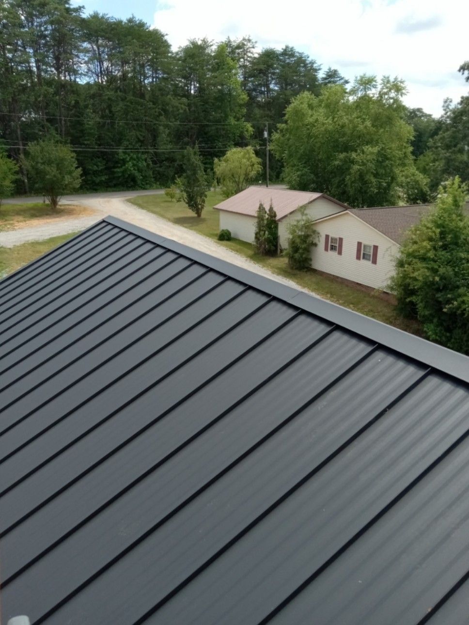 A black metal roof is sitting on top of a house.
