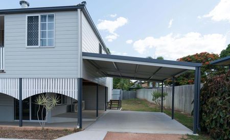 A white house with a carport in front of it