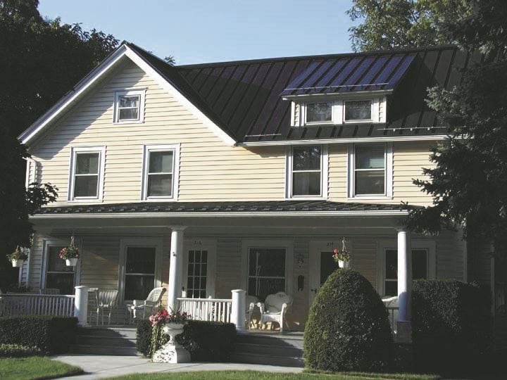 A house with a black roof and a porch