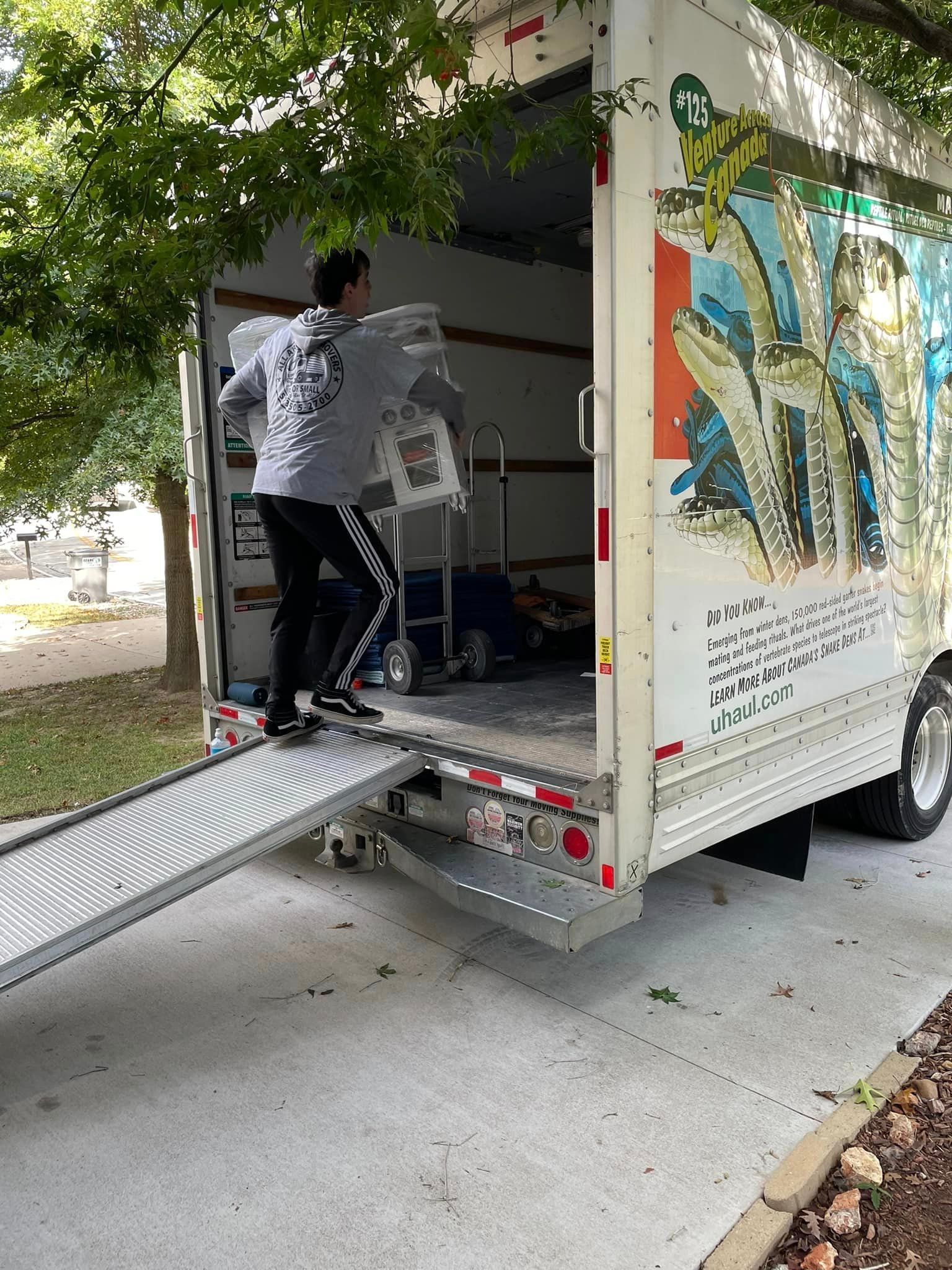 A man is loading a box into a moving truck.