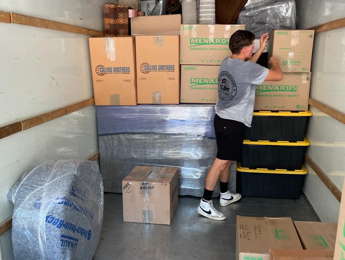 A man is loading boxes into a moving truck.