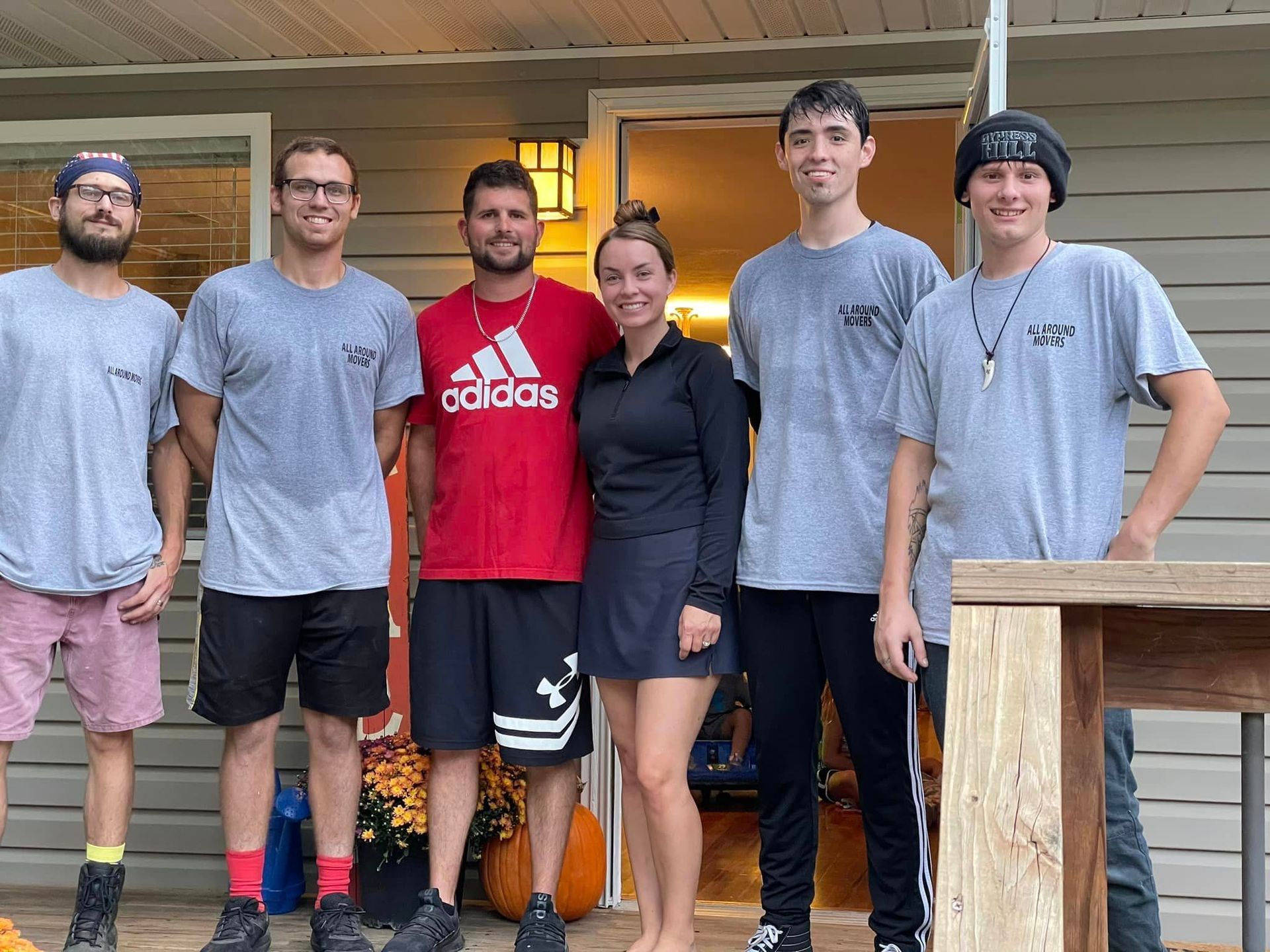 A group of people are posing for a picture in front of a house.