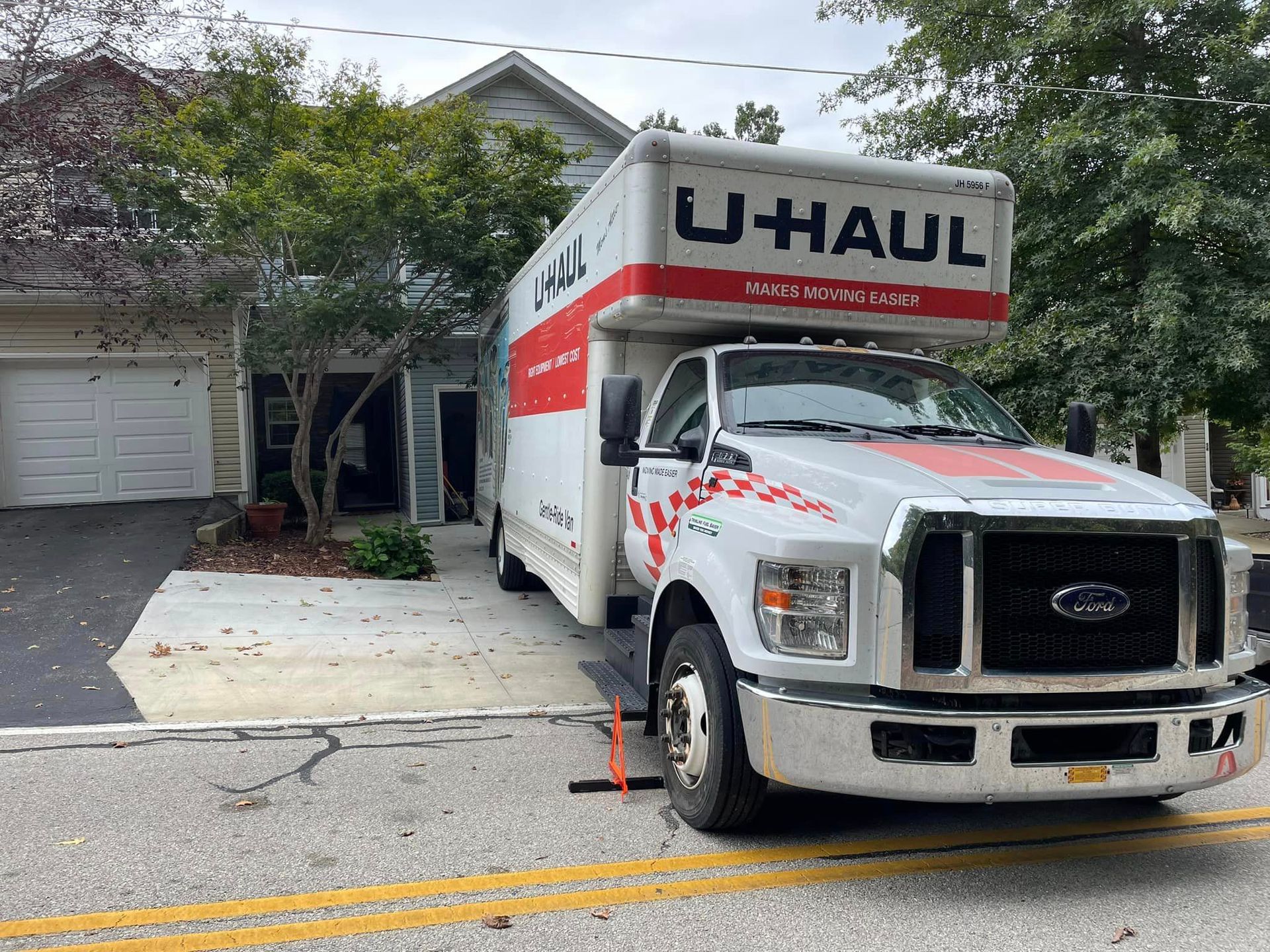 A u-haul truck is parked in front of a house.