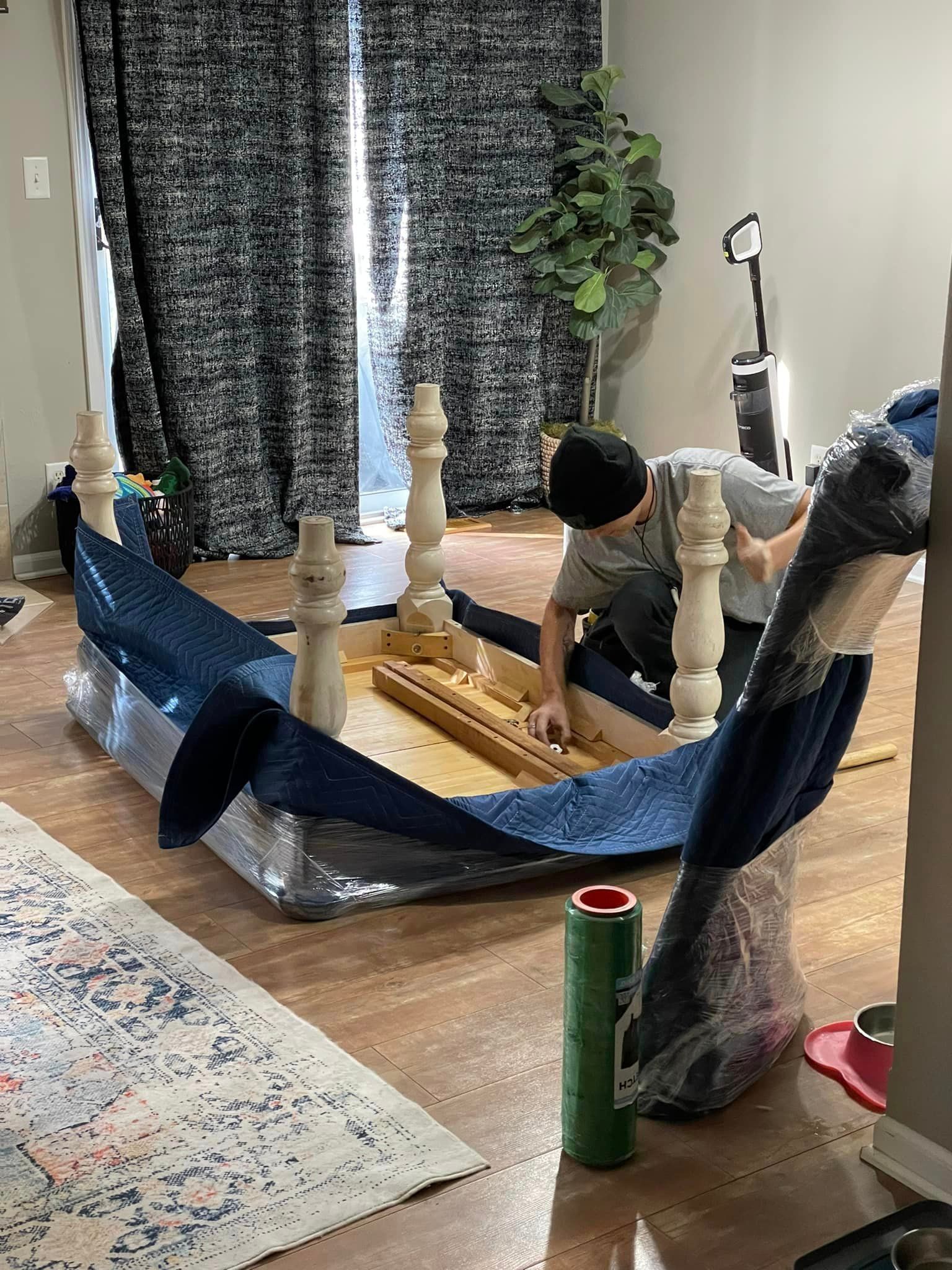 A man is moving a table in a living room.