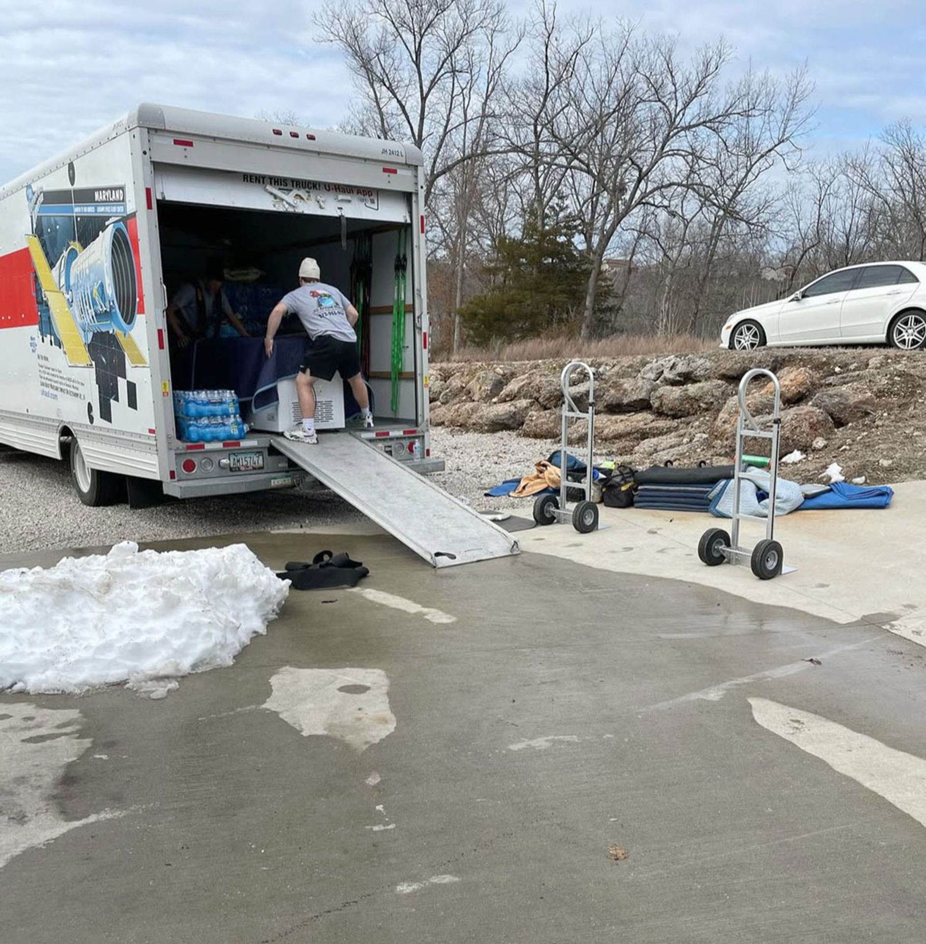 A man is loading a moving truck with a ramp