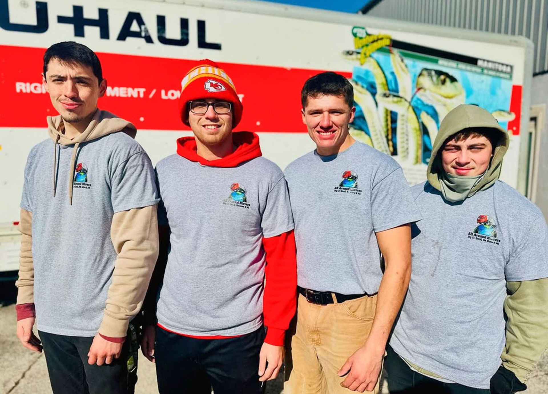A group of men standing beside a moving truck