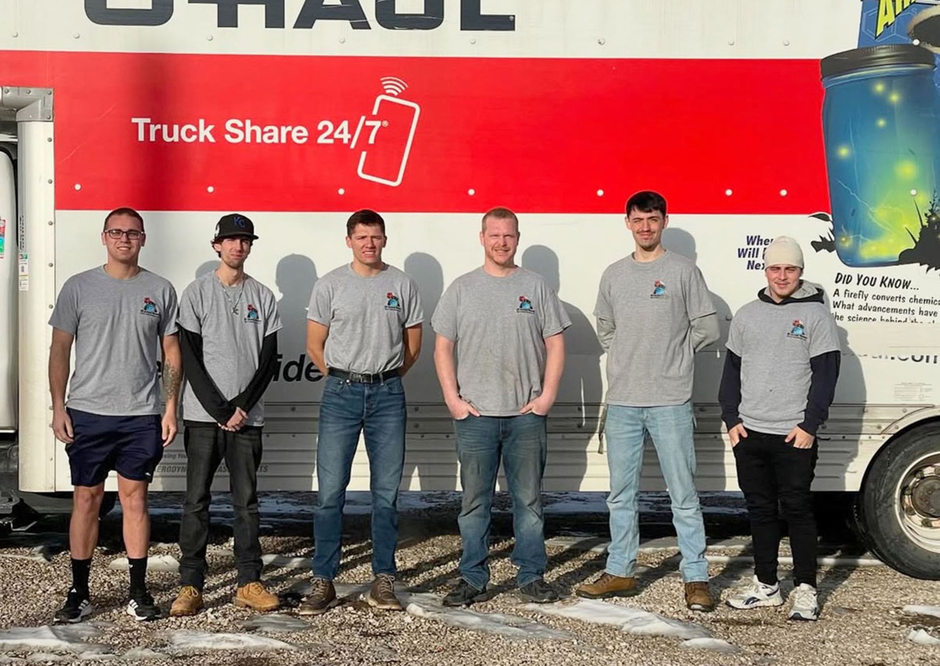 A group of men standing beside a truck