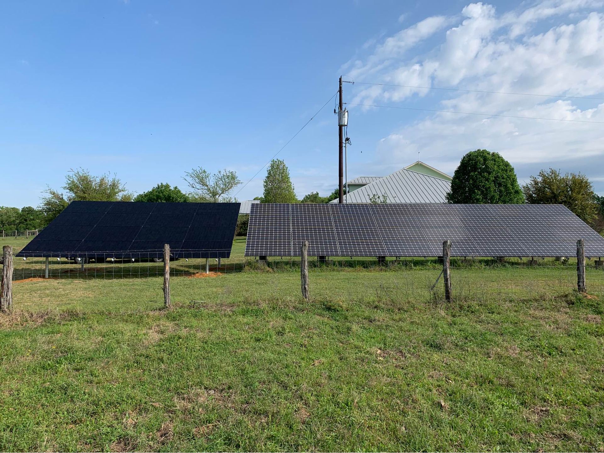 A row of solar panels are sitting in a grassy field.