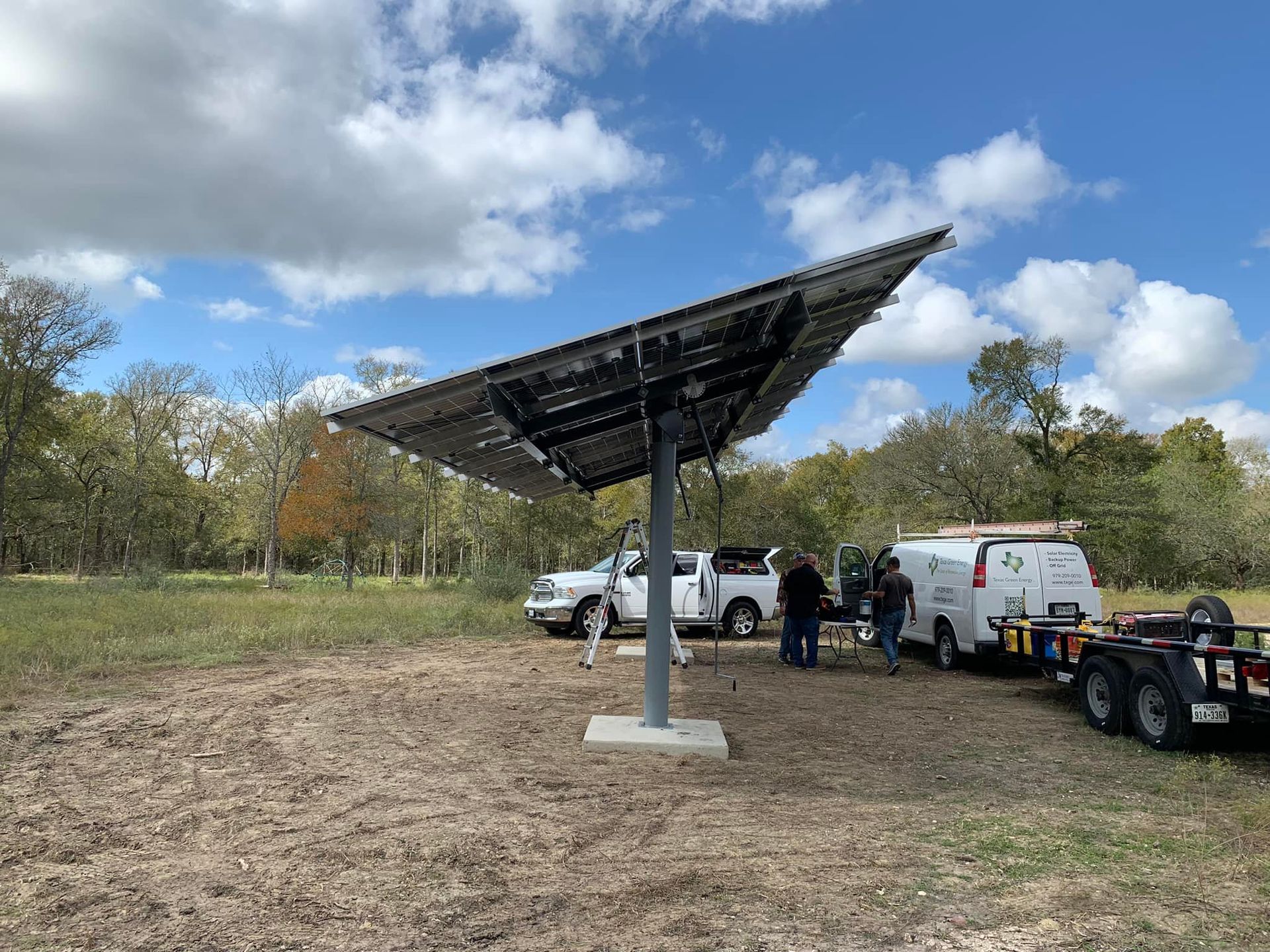 A group of people are working on a solar panel in a field.