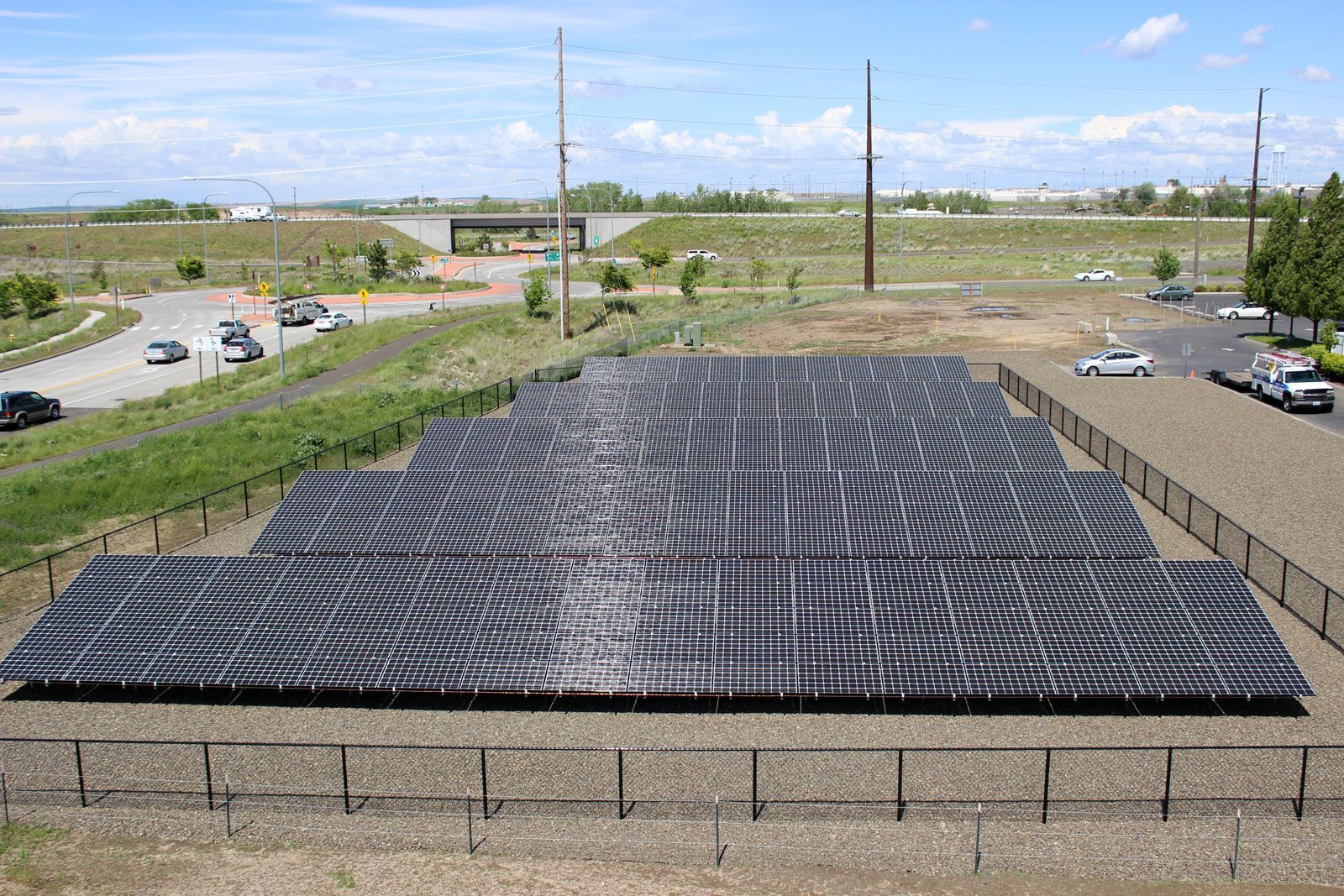 A large amount of solar panels are sitting on top of a dirt field.