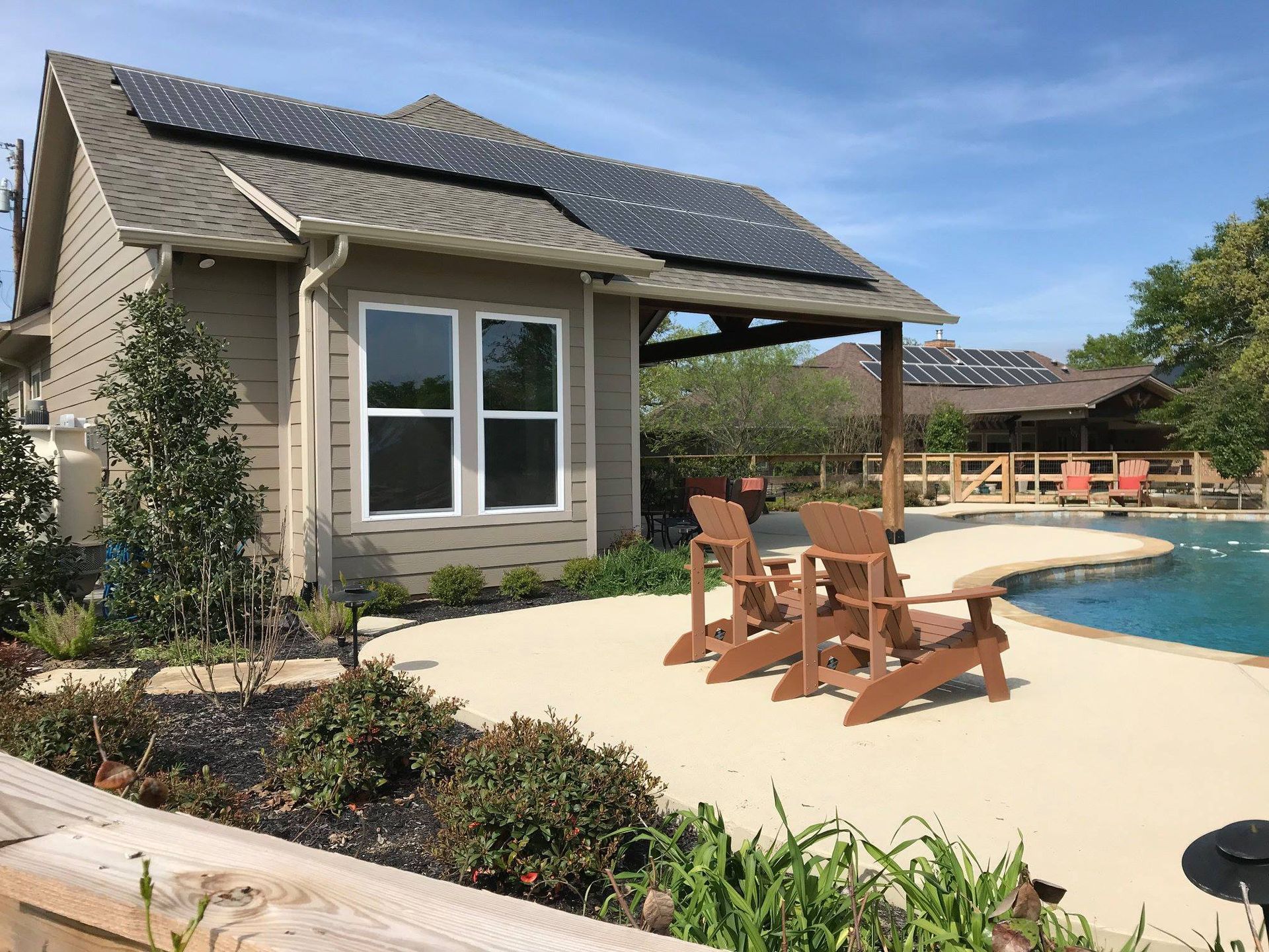 A house with a pool and chairs in front of it