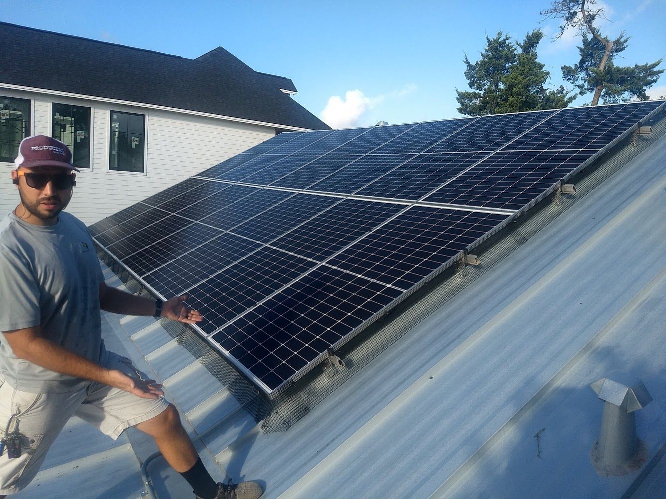A man is standing on a roof with solar panels on it