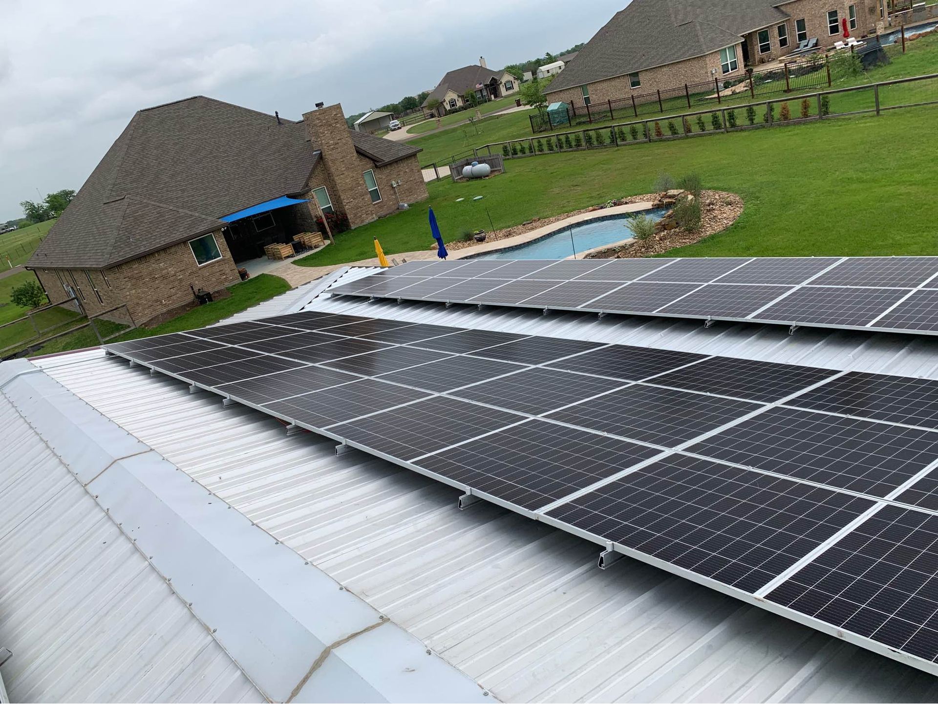 There are many solar panels on the roof of a house.