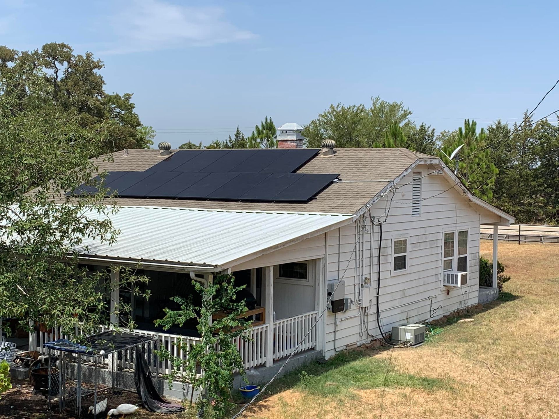 A white house with solar panels on the roof.