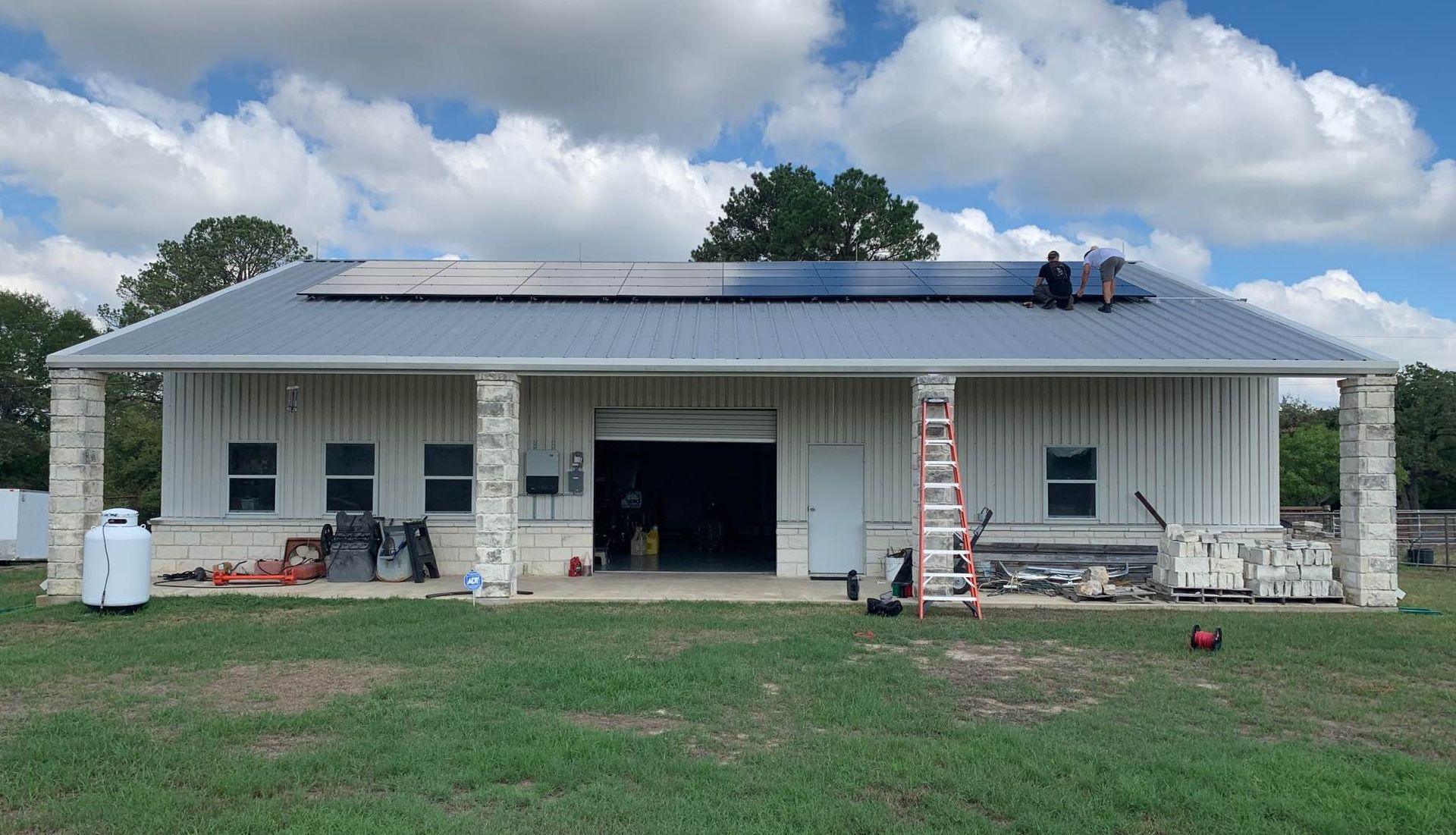 A man is installing solar panels on the roof of a house.