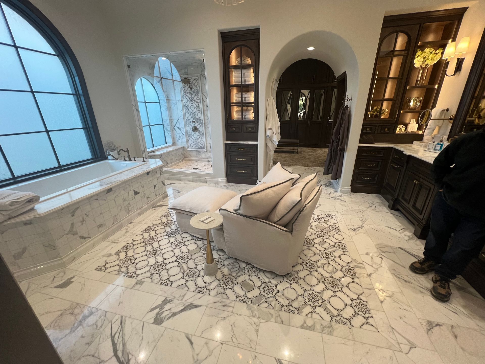 a man is standing in a bathroom with a couch and a tub