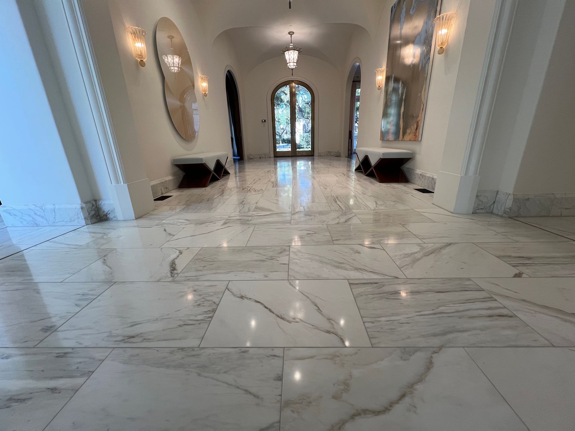 a hallway with a marble floor and a mirror on the wall