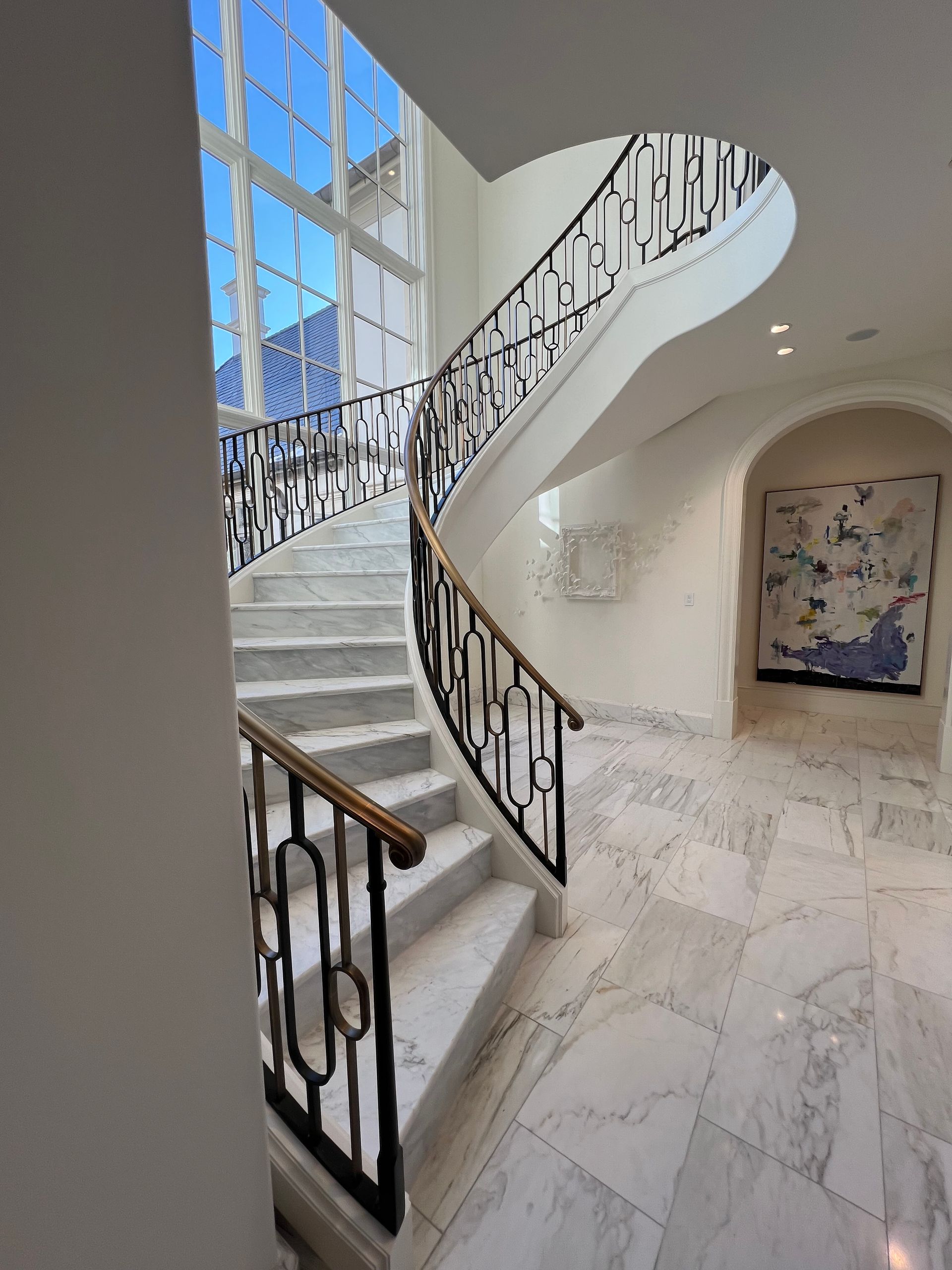 a curved staircase with a wrought iron railing
