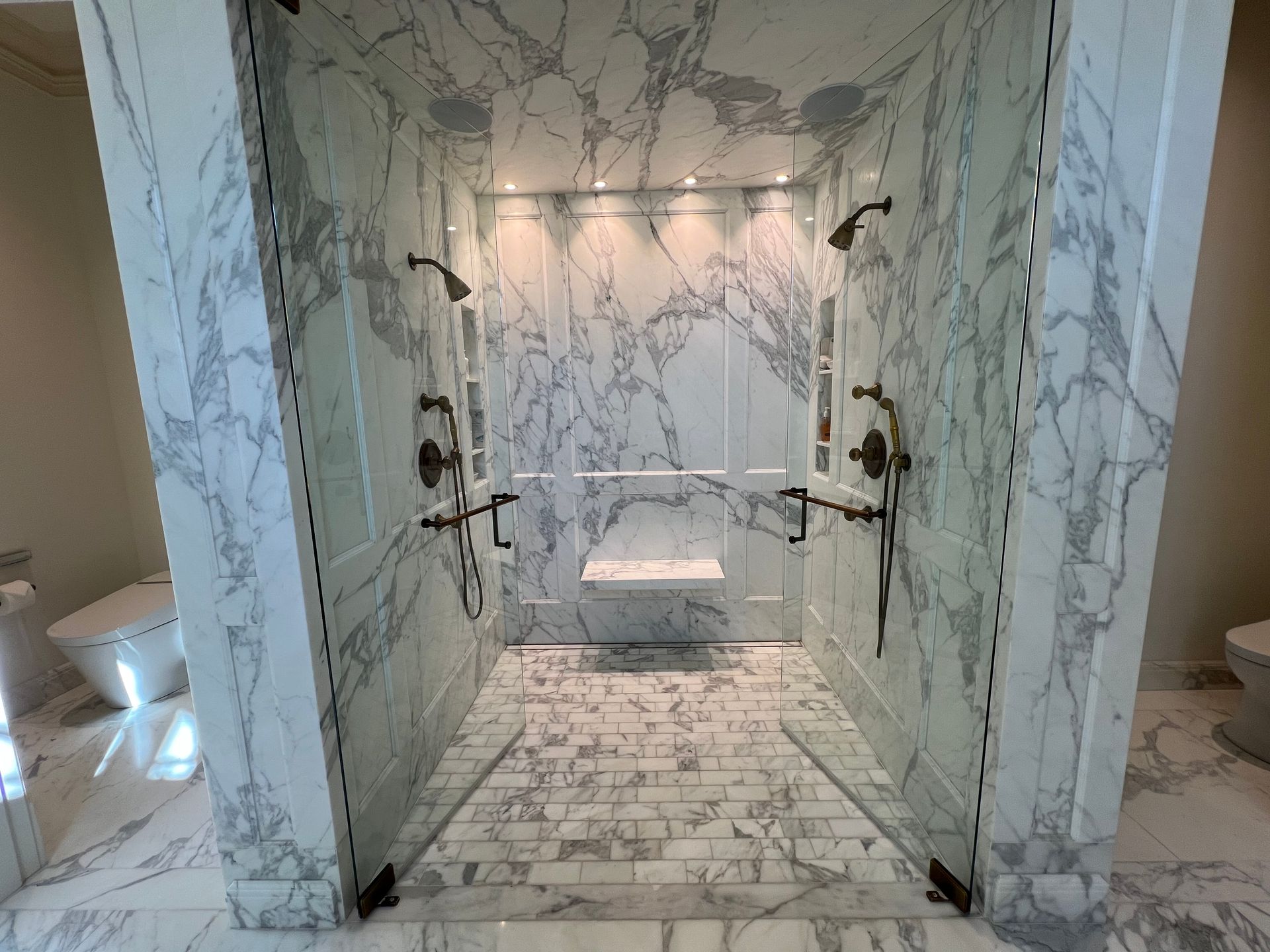 a bathroom with two walk in showers and a toilet
