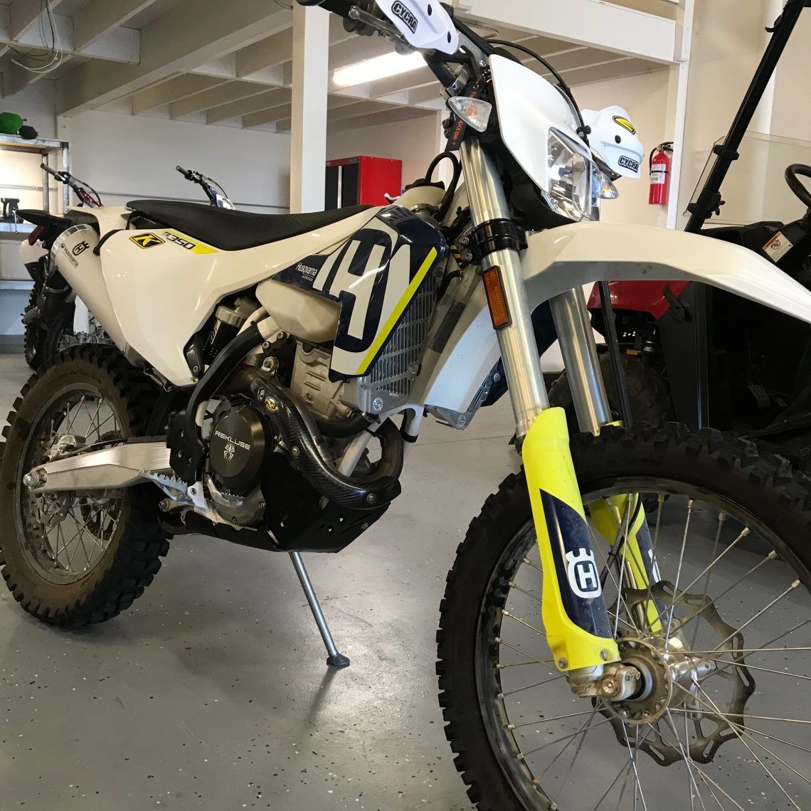 A husqvarna dirt bike is parked in a garage