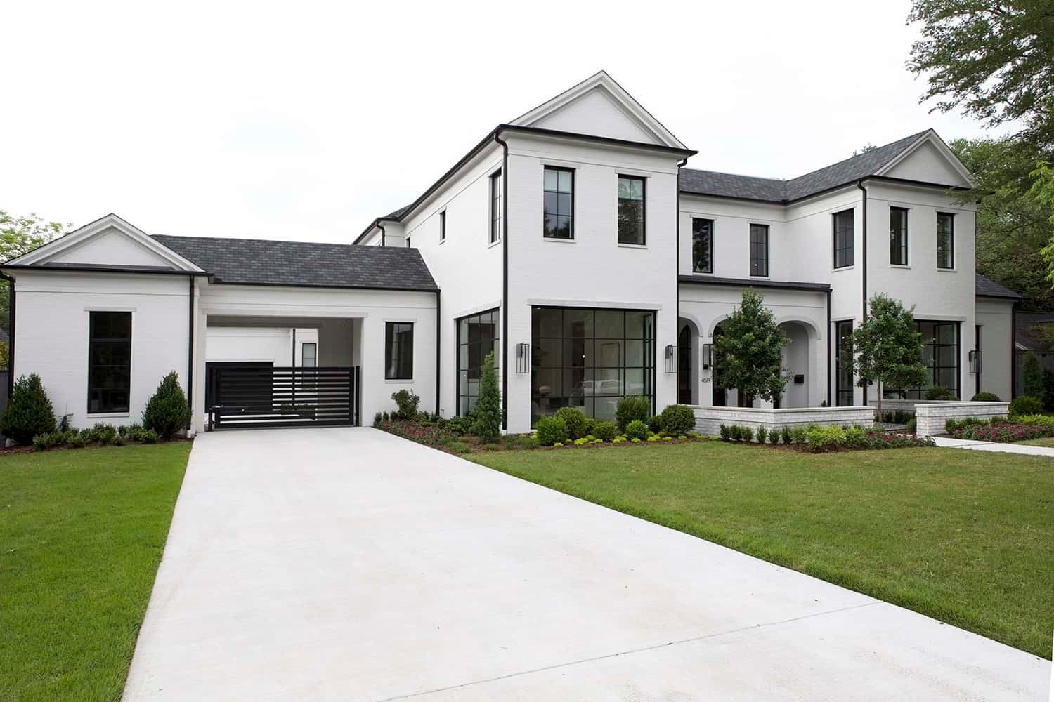 White modern home with black trim and long driveway.