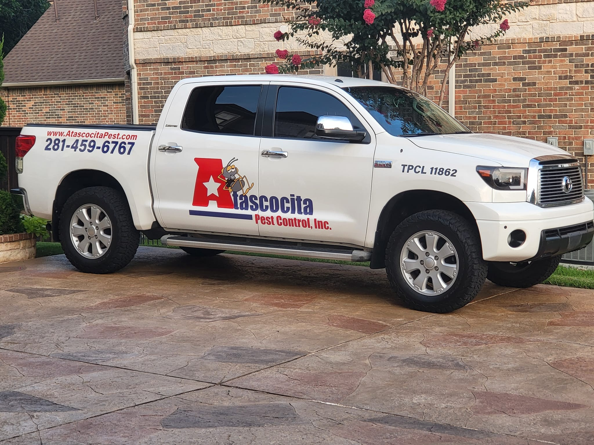 White pickup truck with company logo parked on a driveway.