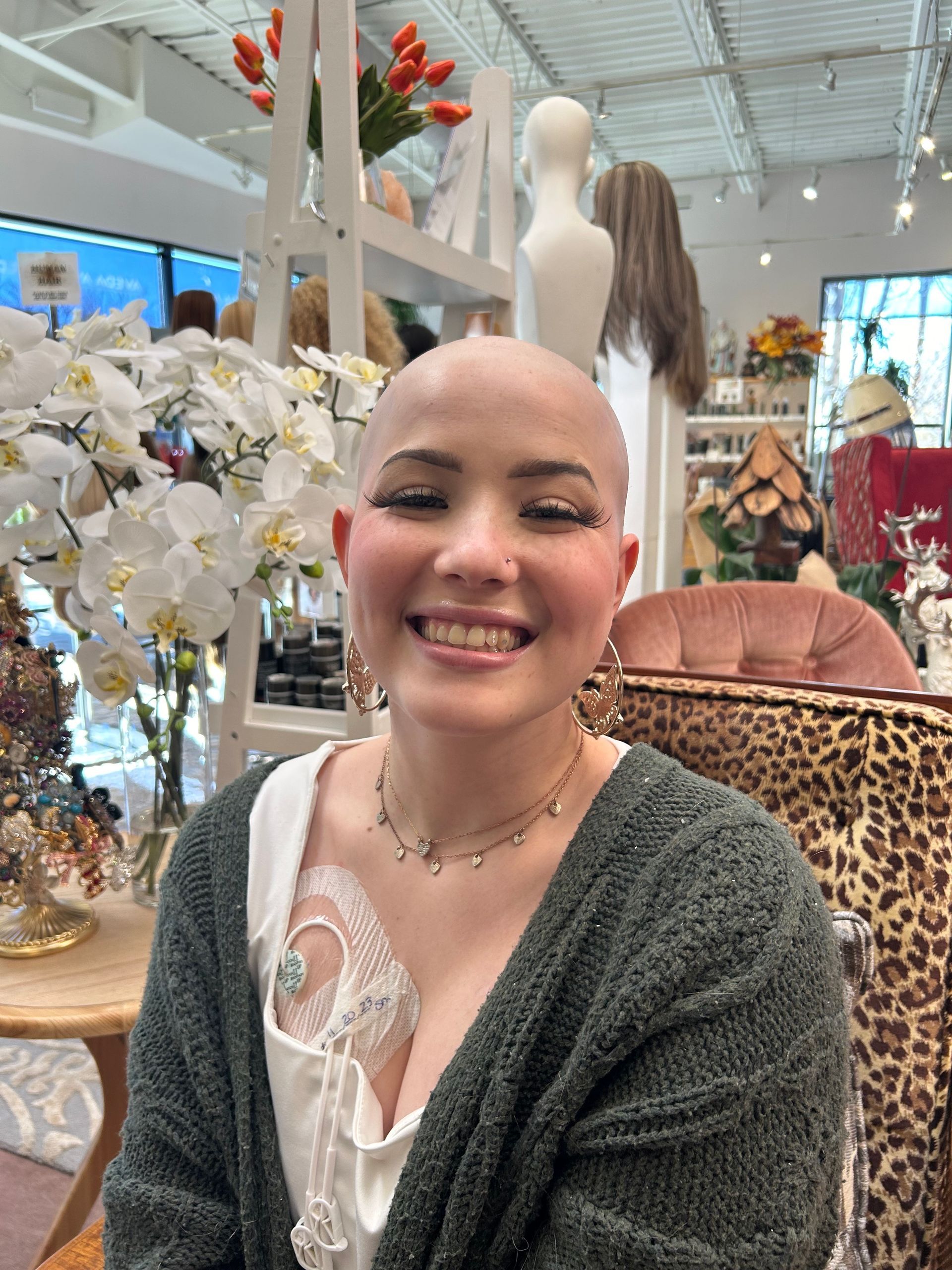 A woman with a shaved head is smiling in a store.