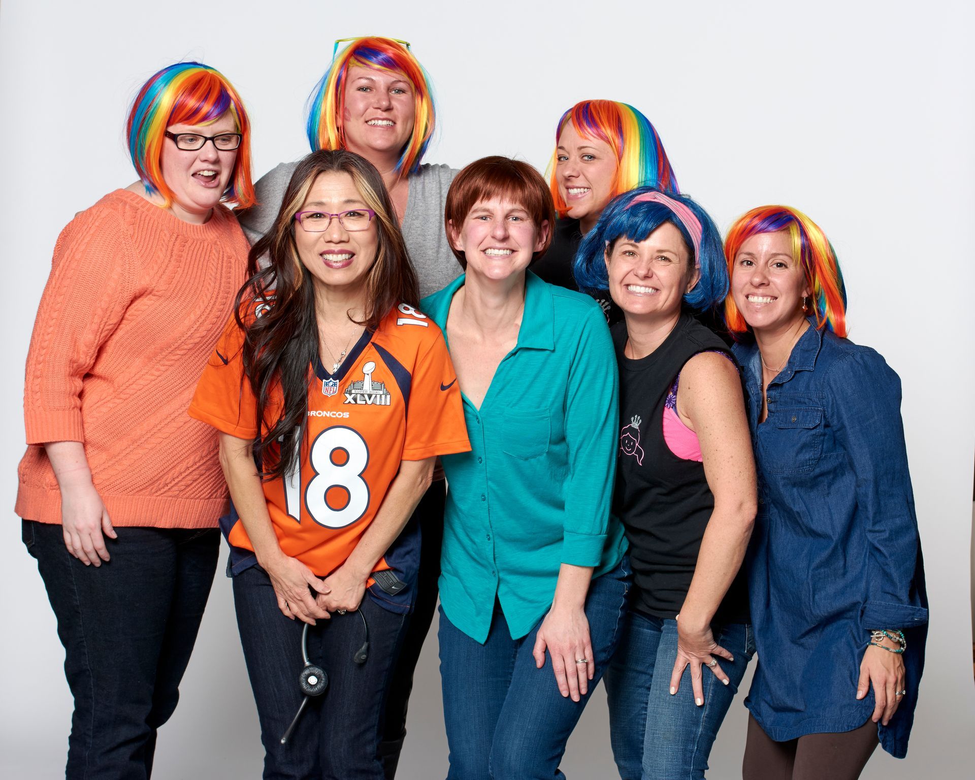 A group of women are posing for a picture with one wearing an 18 jersey