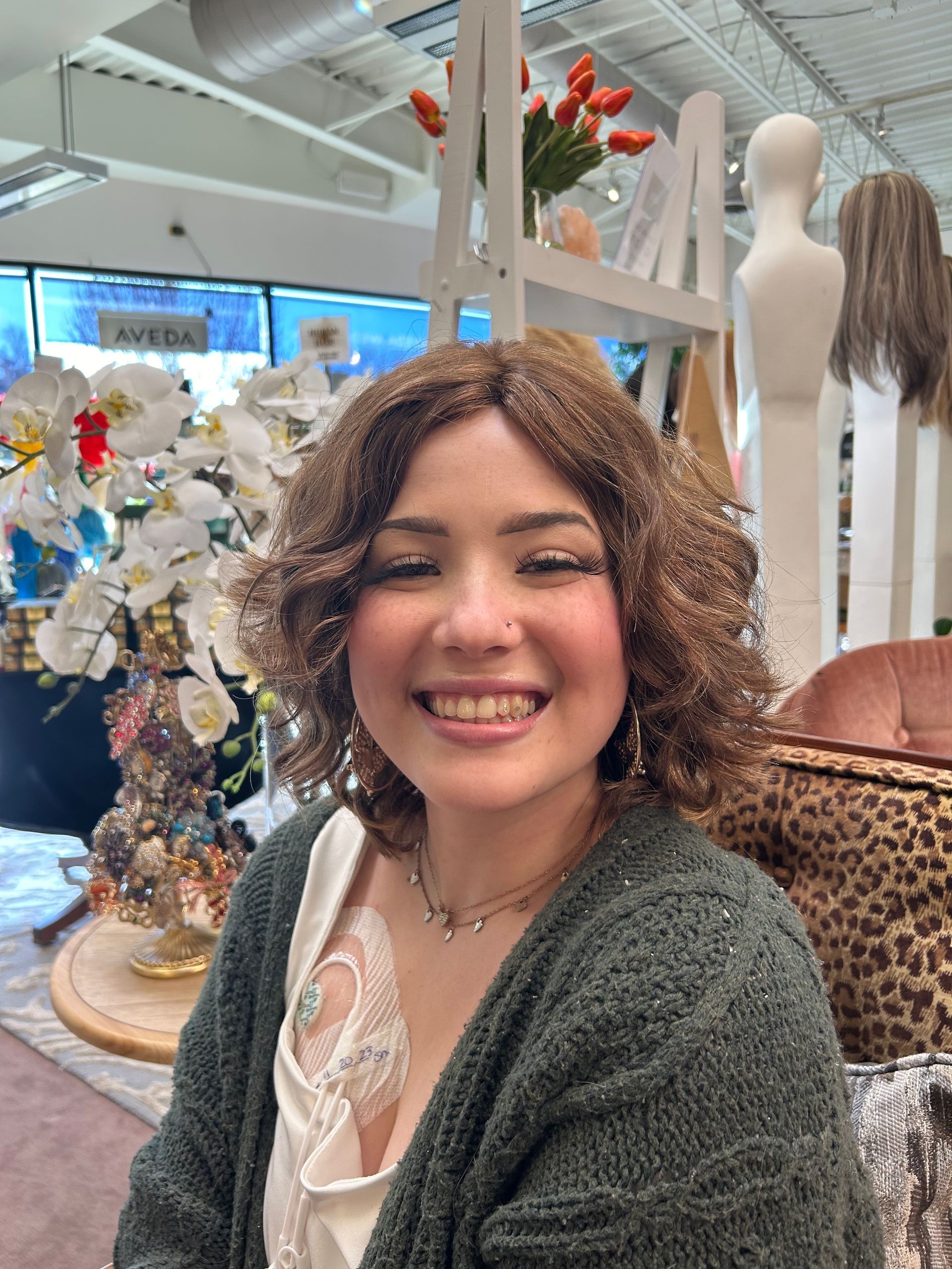 A woman wearing a wig is smiling in a store.
