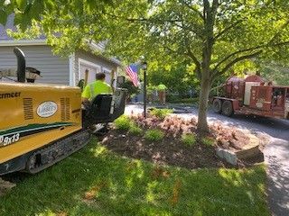 A man is sitting on a machine in front of a house.