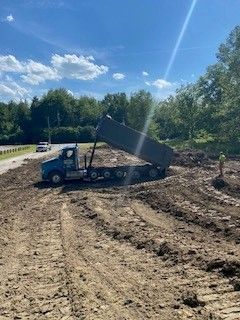 A dump truck is driving down a dirt road.