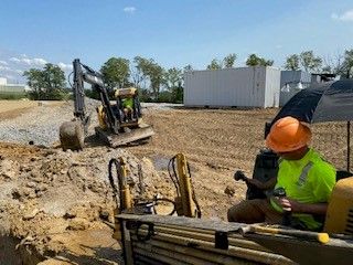A construction worker is sitting in the back of a bulldozer.