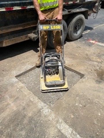 A man is standing next to a machine that says ewp 1550 on it.