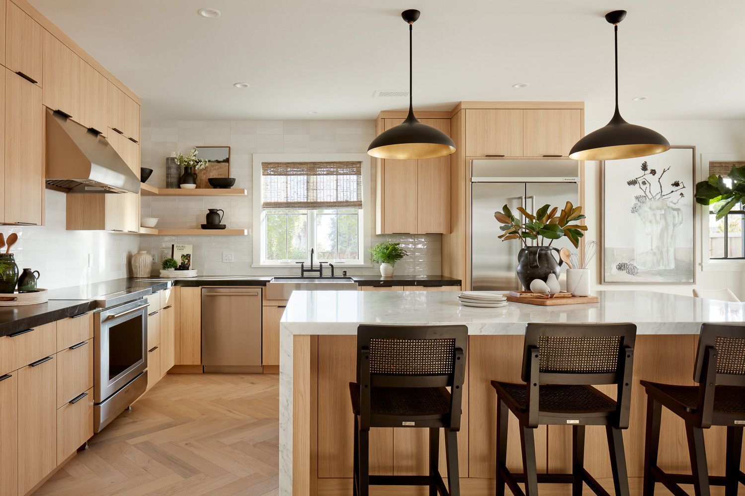 Bright modern kitchen with island, wooden cabinets, pendant lights, and bar stools